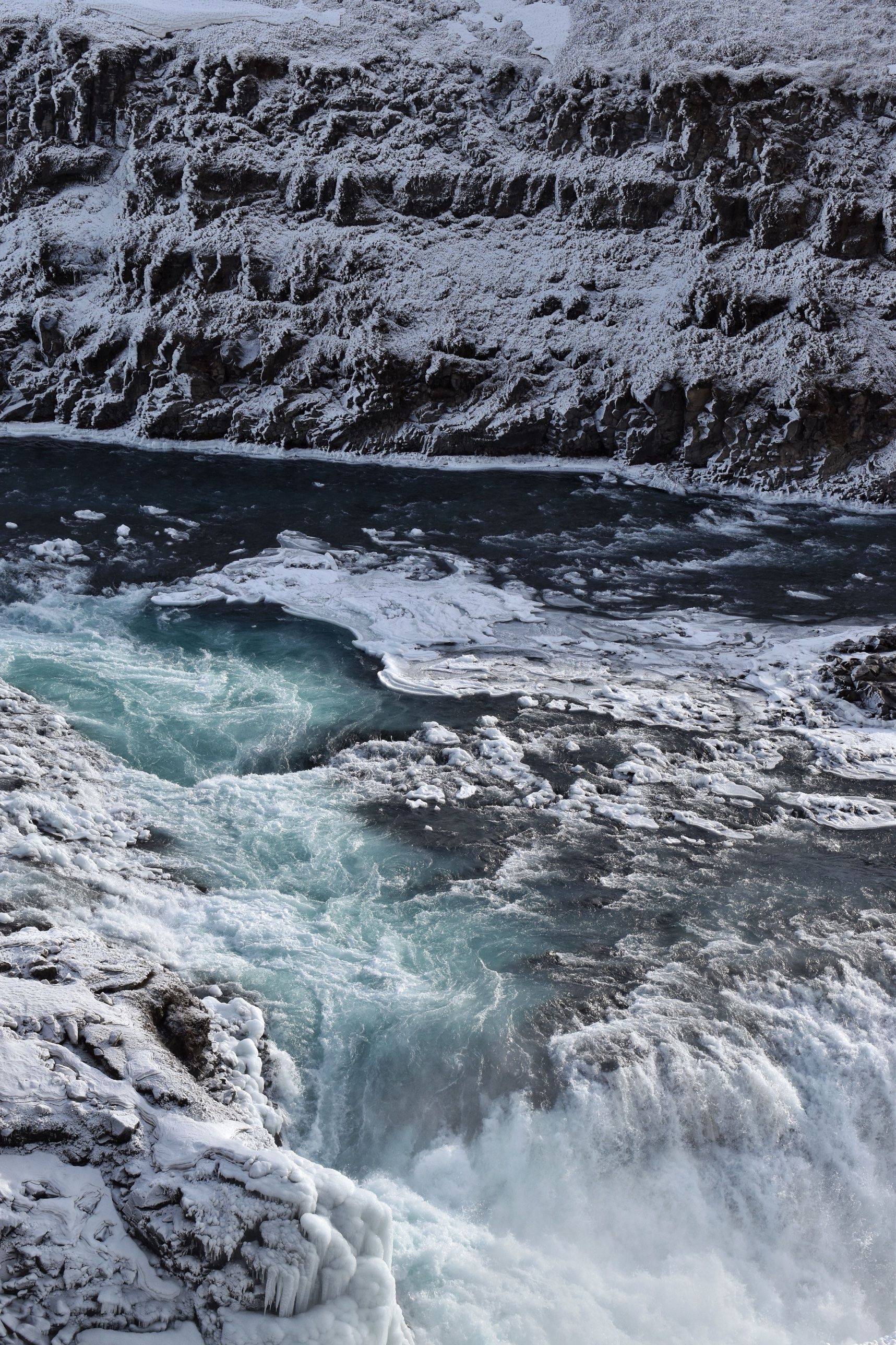 Gullfoss waterfall in winter, its water churning between snow-covered rocks