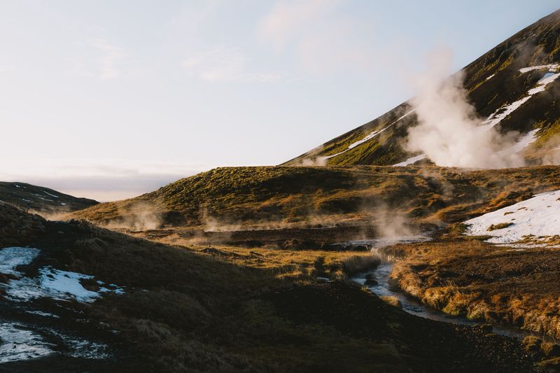 Steam rising from a hot river valley at sunrise